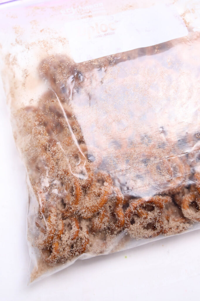 A clear plastic bag filled with sliced bananas coated in brown sugar, sealed and placed on a white surface.